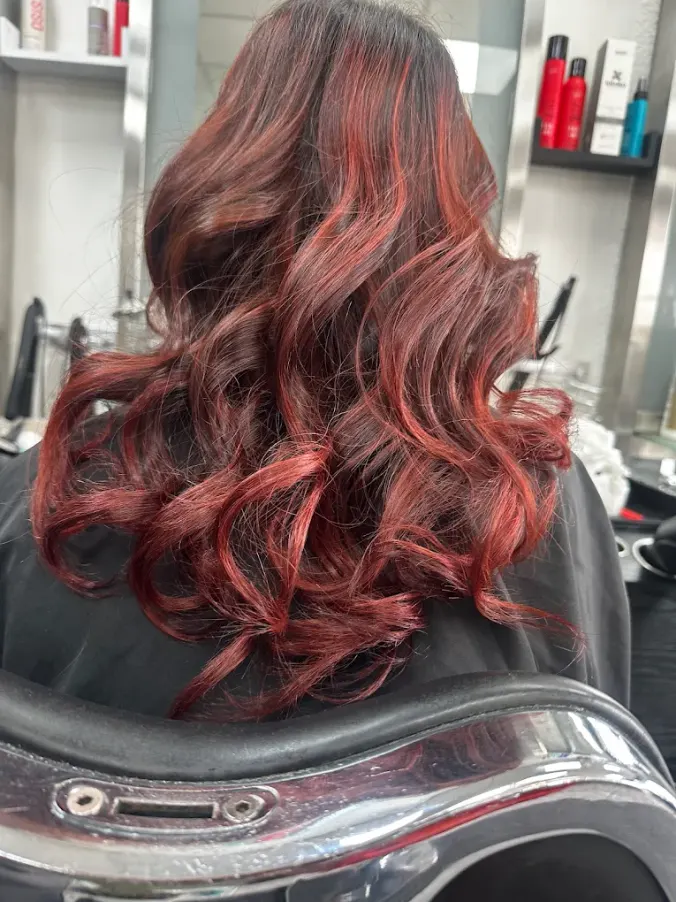 Glossy curled red colour result created at Naz Hair and Beauty