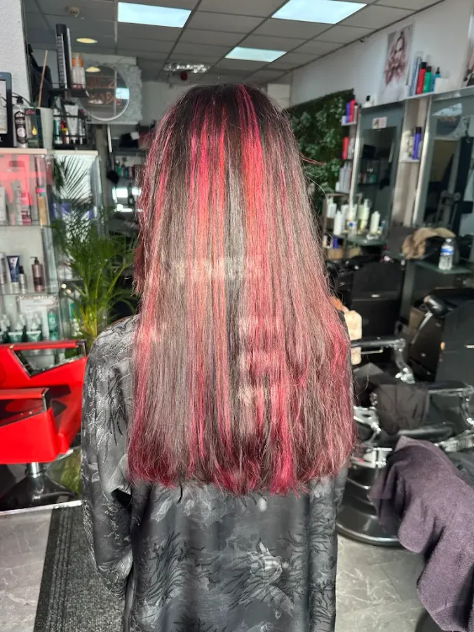 Long smooth dark hair with vivid red ribbon highlights at Naz Hair and Beauty